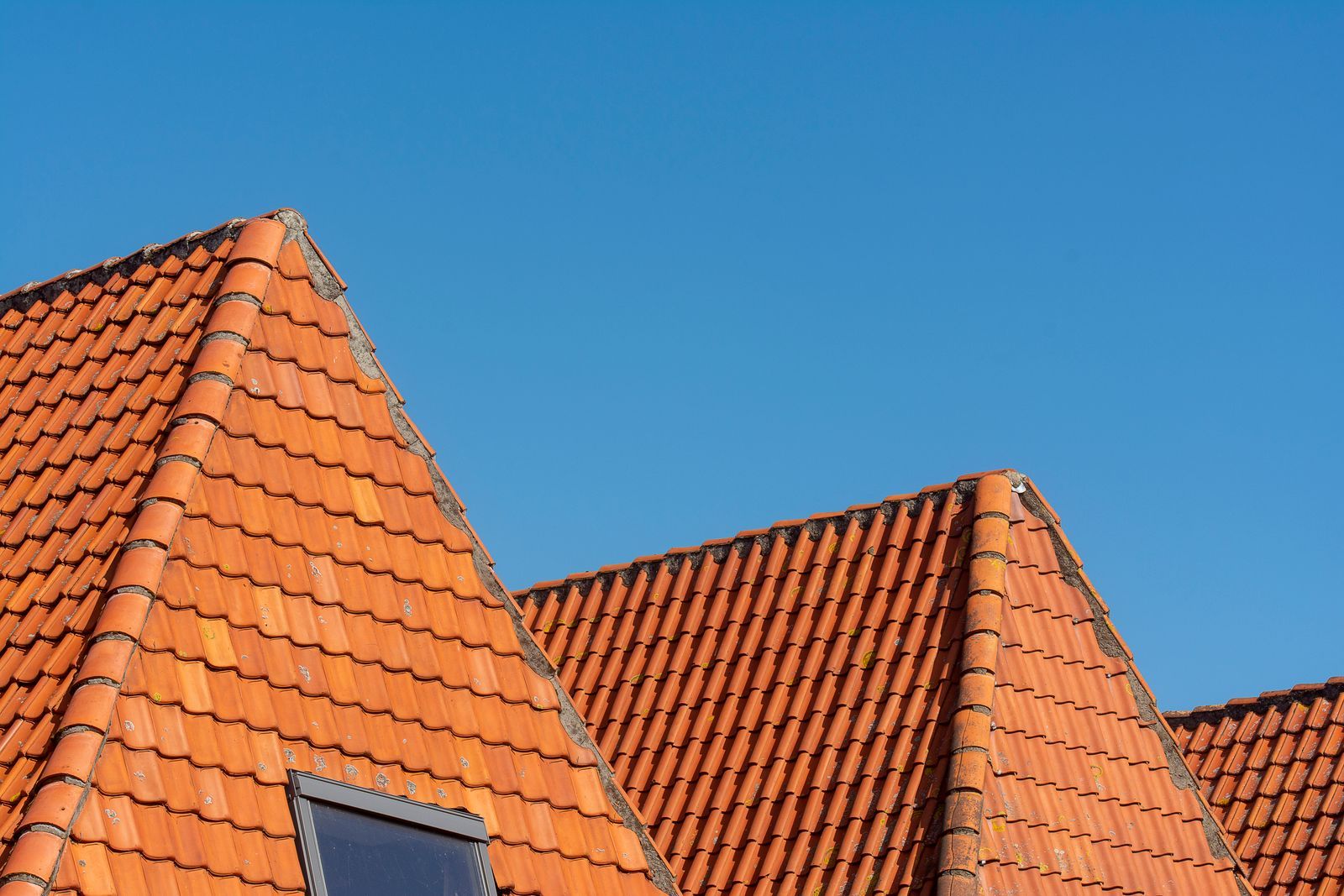 Roofer repairing a pitched slate roof in Central Scotland